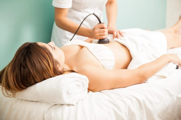 woman receiving body treatment on abdomen in a spa
