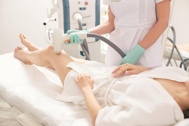 woman receiving laser hair removal on leg in a clinic